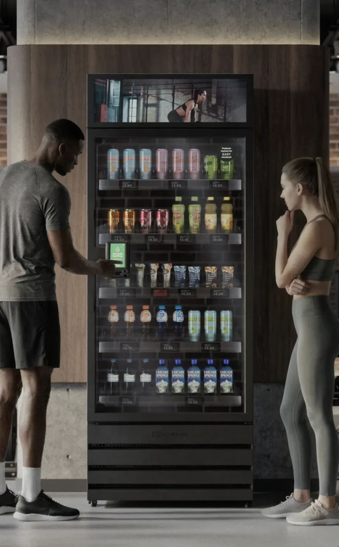 Two people at a single smart store unit stocked with cold drinks